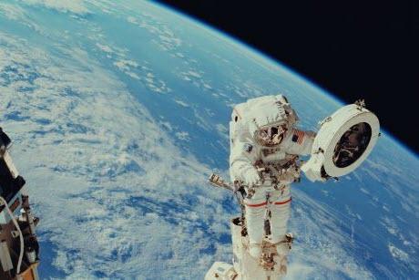 Astronaut floating in space above Earth