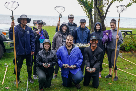 Law students and their quahogging instructor Jody King showing off their 3 dozen quahogs in front of the ocean in which they got them.
