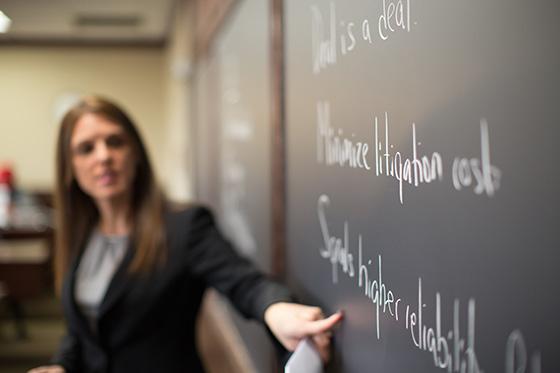 Professor points to notes on chalkboard